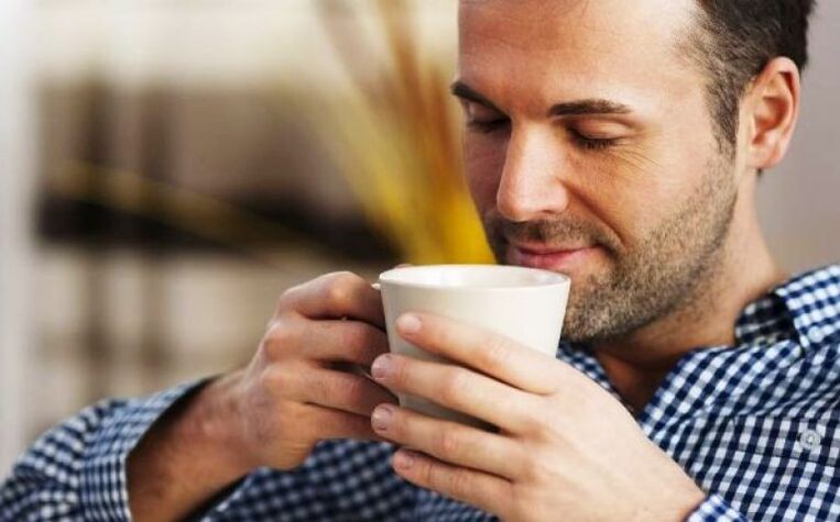 A man drinks a drink of tea from a fireplace to increase activity